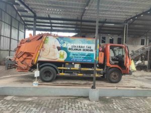 Mobil bermuatan sampah yang sedang memakai timbangan truk